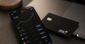 App de Trade Republic en un móvil junto a una tarjeta bancaria.