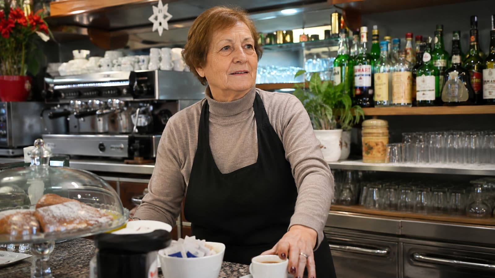 Anna Possi continúa atendiendo su bar de Nebbiuno en el norte de Italia.