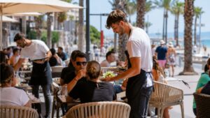Camareros atienden una terraza en temporada alta en Playa de Palma donde la hostelería afronta más candidaturas pero también más rotación laboral